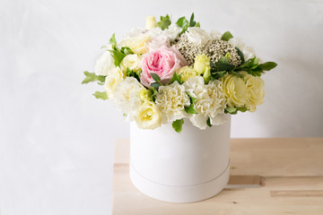 Beautiful tender bouquet of flowers in white box on light ackground with space for text
