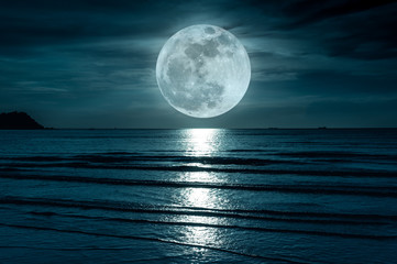 Plakaty  Super Księżyc. Kolorowe niebo z chmurą i jasny księżyc w pełni nad pejzażem morskim.