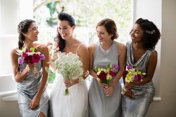 Bride and bridesmaids standing with bouquet - obrazy, fototapety, plakaty