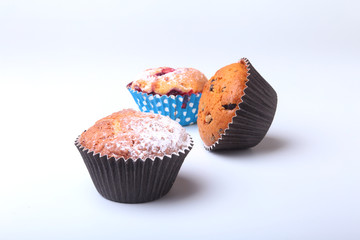 Homemade Blueberry and chocolate muffins with powdered sugar and fresh berries.