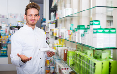 Adult pharmacist standing among shelves