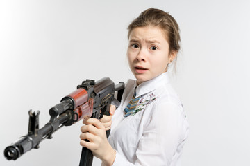 Girl with a frightened look with a Kalashnikov in his hand. Isolated