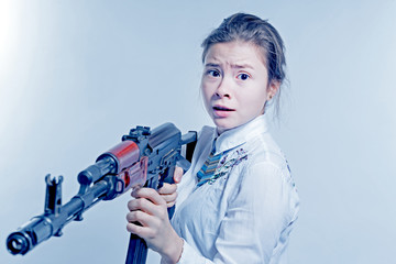 Girl with a frightened look with a Kalashnikov in his hand. Isolated