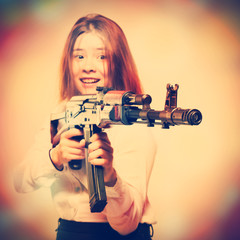 Girl smiling with Kalashnikov in hand