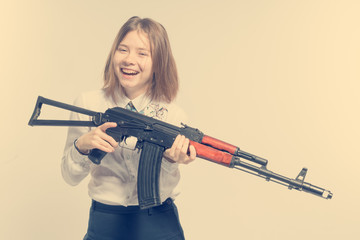 Girl smiling with Kalashnikov in hand. Isolated