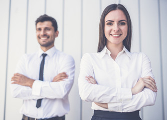 The happy woman and man stand in the office