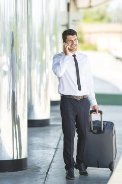 The businessman phone and walk with a suitcase