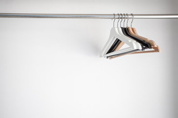 Wooden hangers on white wall background