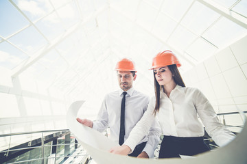 The two engineers hold the project plan in the building