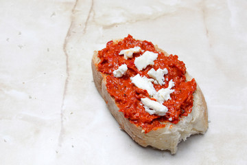 Pieces of a cheese on traditional macedonian food ayvar smeared on a bread .homemade product