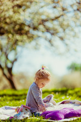 Girl plays in the rays of sun on the lawn