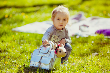 Girl with silver bag sits on the green lawn