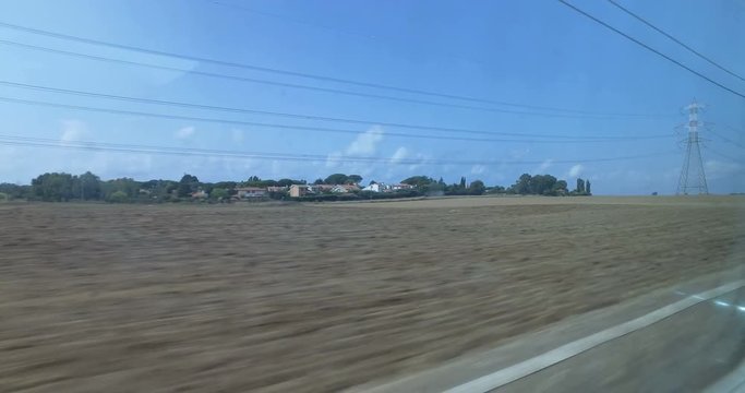 Vista fuori dal finestrino di un treno in movimento.