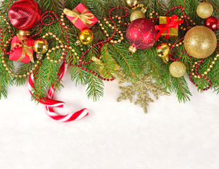 Christmas decorations on a spruce branch on a white