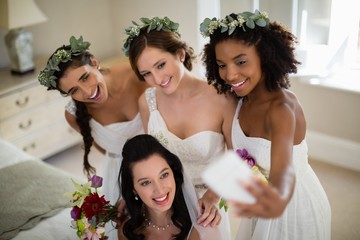 Bride and bridesmaid taking selfie at home