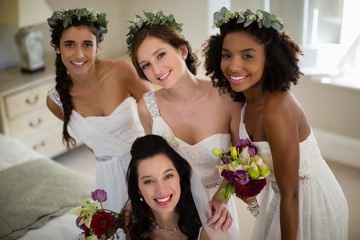 Portrait of smiling bride and bridesmaid in living room