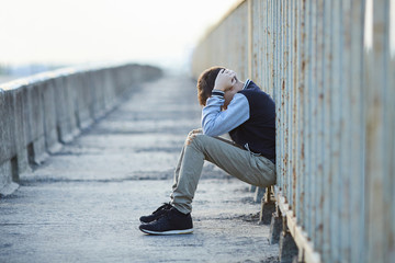 young homeless boy  crying on the bridge