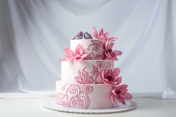 A beautiful home wedding three-tiered cake decorated with pink flowers