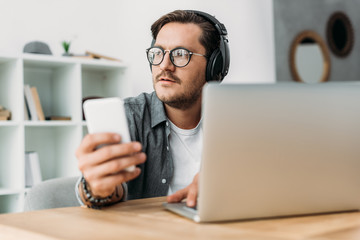 man in headphones using smartphone