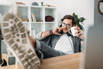 man with headphones drinking coffee