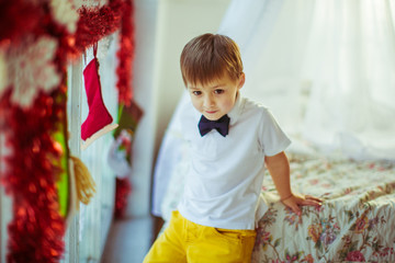 Nice little boy in white shirt and yellow trousers