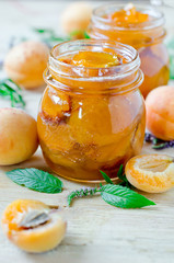 Apricot jam in a jar on a wooden table