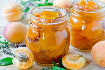 Apricot jam in a jar on a wooden table