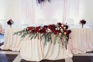 Garland of roses, gerberas and dahilas lies on a table