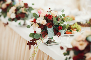 Bouquets of beige and red flowers stand on the table
