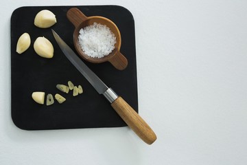 Chopped garlic with bowl of sea salt and knife