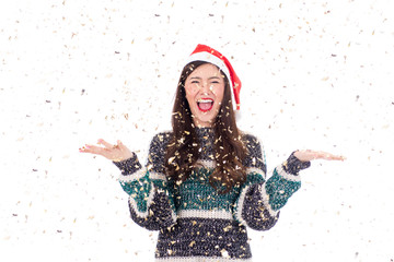 Young happy asian woman with santa hat enjoying with confetti isolated on white background, christmas and happy new year concept.