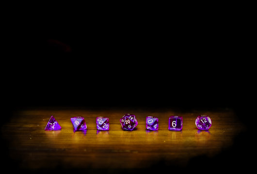 dadi viola in fila con luce e sfondo nero