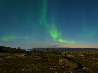 Autumn Aurora over the hills and reflected in the lake.