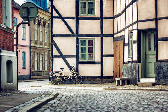 Yellow bicycle near the building facade with a window, Scandinavian style. Street in Lund, Sweden
