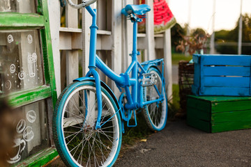 The decoration of vintage bicycle and white building with green door. Old blue retro bike and holiday house background.