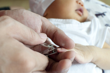 Cutting the nails of a newborn baby