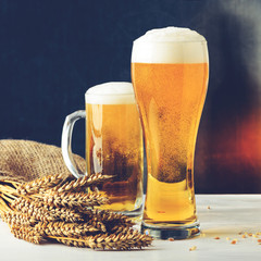 Fresh beer in two glasses against dark background. Concept of Octoberfest, food and drinking, toned image