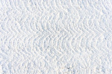 Fototapeta na wymiar Road in winter, texture of snow and and traces of the tread