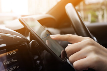 Woman driving a car with using navigation on smartphone.technology concepts