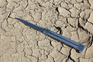 Parched ground and butterfly knife/ This is a detail of parched ground-dry puddle with butterfly...