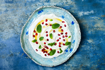 Labneh middle eastern lebanese cream cheese dip with pomegranate, molasses and mint. Top view, copy space - obrazy, fototapety, plakaty