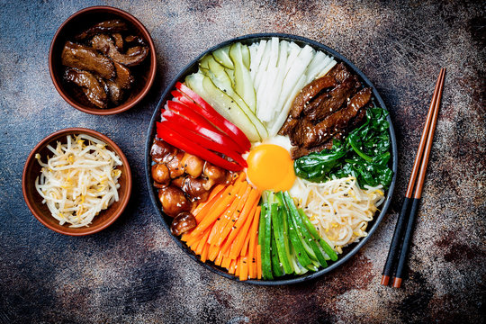 Bibimbap, traditional Korean dish, rice with vegetables and beef. Top view, overhead, flat lay