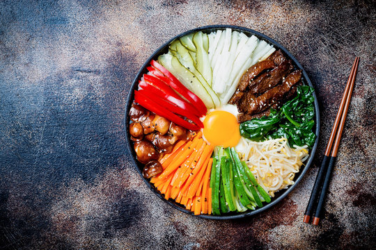 Bibimbap, traditional Korean dish, rice with vegetables and beef. Top view, overhead, flat lay, copy space
