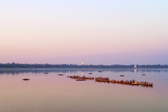 Traditional burmese boats on Taungthaman Lake at sunset, in Amarapura, Mandalay, Myanmar