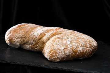 front view of fresh warm homemade bread on dark background