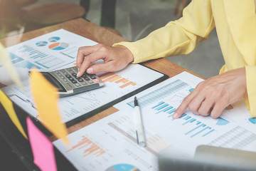 Businesswoman working at his coffee shop and using laptop,  discussing the charts and graphs showing the results of their successful.