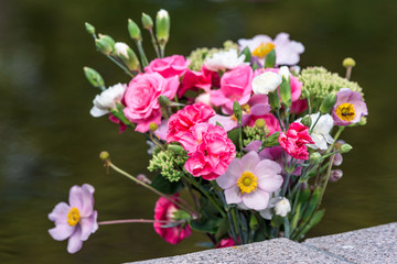 Lovely bouquet of mixed flowers in red, pink and white with water as background.