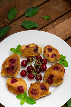 Pancakes with cherries. Wooden background. Close-up. Top view