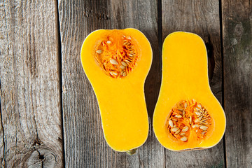 Top view Cut ripe orange pumpkin with seeds on the rustic wooden table. Vegetarian, vegan, healthy diet food. Autumn harvest concept . Selective focus. Space for text