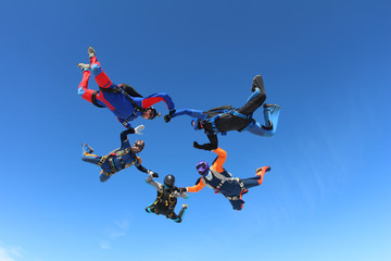 Skydivers in the blue sky.